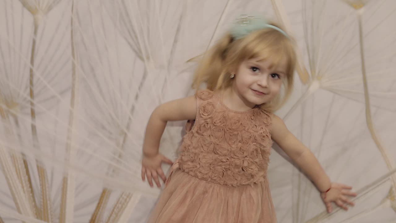 feliz niña de tres años hacer caras y bailar. niño rubio lindo