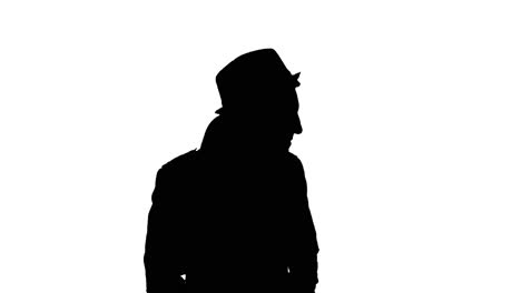 man in long coat puts on hat, black silhouette on white background