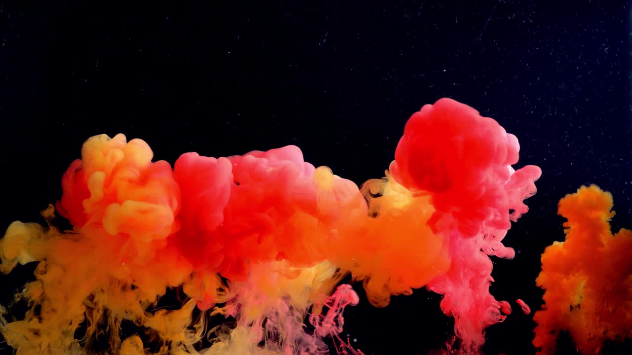 salpicaduras de color de tinta aislados en fondo negro. pintura abstracta en el agua, fotografiado en movimiento. girando gotas de colores nube.