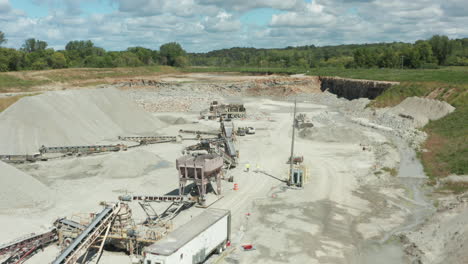 Luftaufnahme-Eines-Kalkstein-Sand-Steinbruchs-Mit-Förderbändern,-Die-LKWs-Für-Den-Bau-Beladen