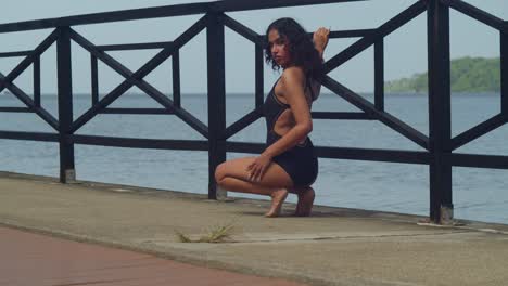 a young girl, wearing a bikini, soaks up the beauty of a caribbean beach as she walks along the boardwalk.