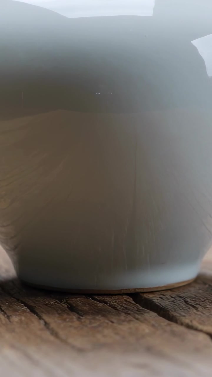 Vertikal video: Glidande kamera avslöjar glansig koppbas på köksbänk, exponerar träspricka.