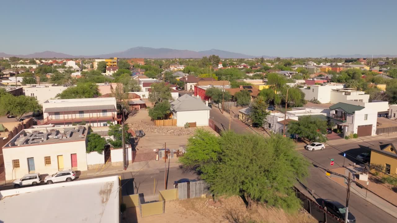 Aerial view of a town or residential area with houses, streets, and distant mountains
