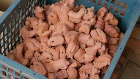 Top-tight-view-of-hand-placing-asian-pottery-clay-figurines-into-crate,-Than-Ha-Hoi-An-Vietnam