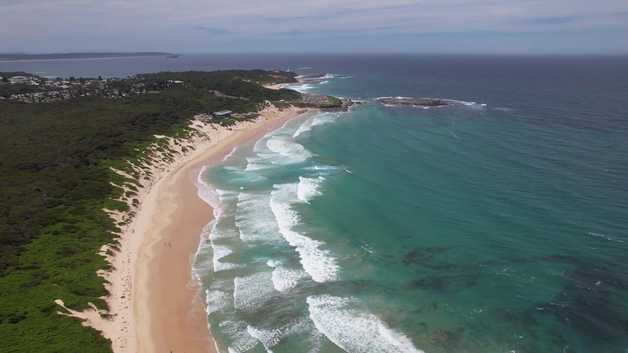 Soldiers Beach med hvidt sand og turkisblåt hav i New South Wales, Australien - Luftfoto.