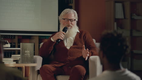 elderly author answering questions from audience at book release event