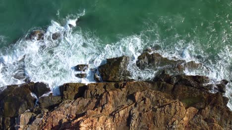 aerial landscape view (drone shot) of sea waves crashing against the rocks at khao laem ya, rayong, thailand