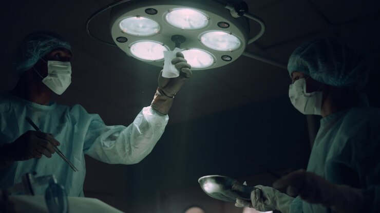 Doctor adjusting surgery lights in operating room. Hospital intensive care unit.