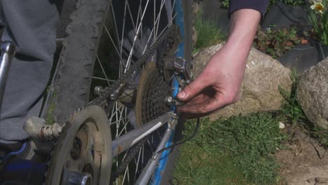 El-Hombre-Inserta-La-Rueda-De-La-Bicicleta-En-La-Bicicleta-Vieja-Y-Se-Pone-La-Cadena