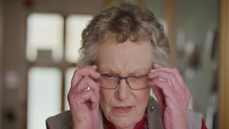 portrait-of-old-retired-woman-putting-on-glasses-in-retirement-home-eyesight-vision