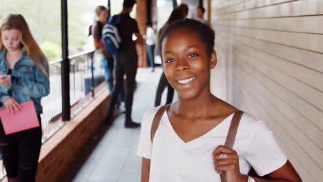 Portrait-Of-Female-Student-Walking-Into-Focus-Outside-Building