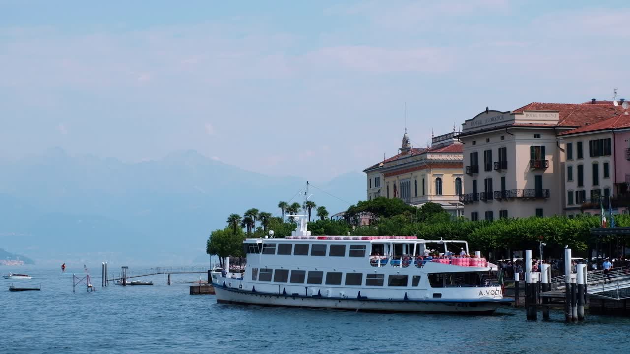 Ferry on a lake with buildings and mountains