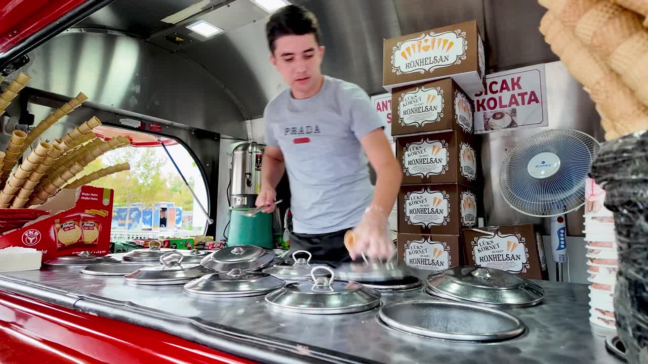Step into the vibrant atmosphere of a Konya, Turkey marketplace and witness the skilled and theatrical performance of a gelato vendor as they expertly craft and serve ice cream, engaging customers