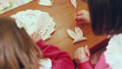 mother and daughter decorating easter cookies