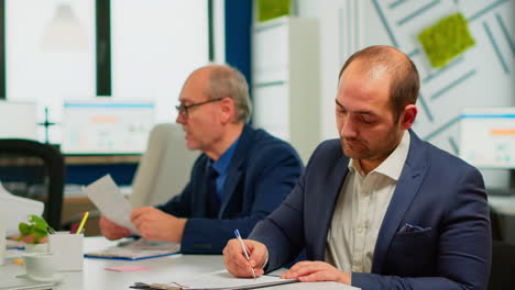 hombre de negocios leyendo un documento en papel, discutiendo un contrato con un socio confiado