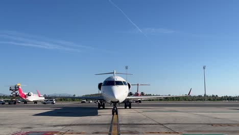 el avión de tamaño medio maniobra para estacionar en el stand antes de desembarcar a los pasajeros.