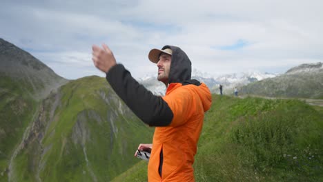 Primer-Plano-Medio-De-Un-Hombre-Vestido-Con-Una-Chaqueta-Naranja-Despegando-El-Dron-Con-Las-Manos,-Estático