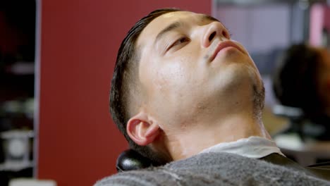 man getting his beard shaved with straight razor 4k