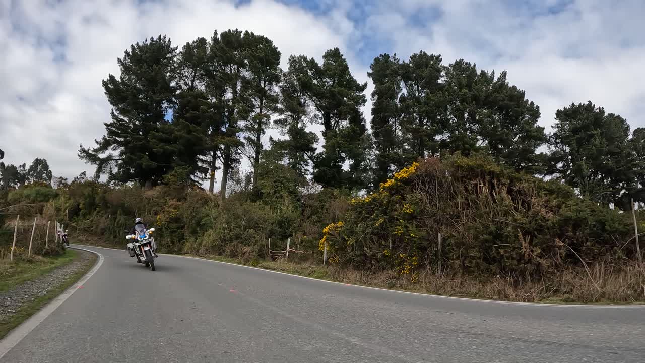group of motorcyclists on asphalt road in northern Chilean Patagonia. Carretera Austral