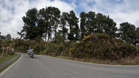 group of motorcyclists on asphalt road in northern chilean patagonia. carretera austral