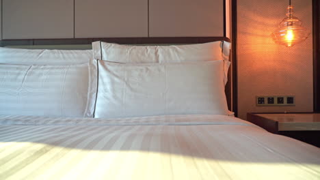 Pan-left-to-right-across-a-made-up-hotel-room-bed