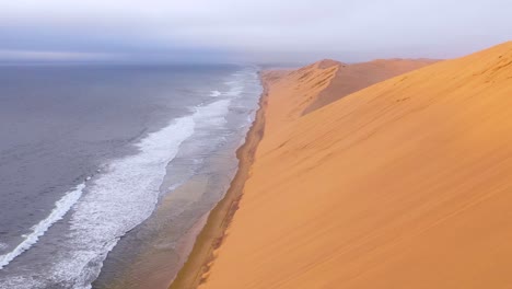 Toma-Aérea-Asombrosa-Sobre-Las-Vastas-Dunas-De-Arena-Del-Desierto-De-Namib-A-Lo-Largo-De-La-Costa-De-Los-Esqueletos-De-Namibia-Termina-En-Una-Furgoneta-De-Safari