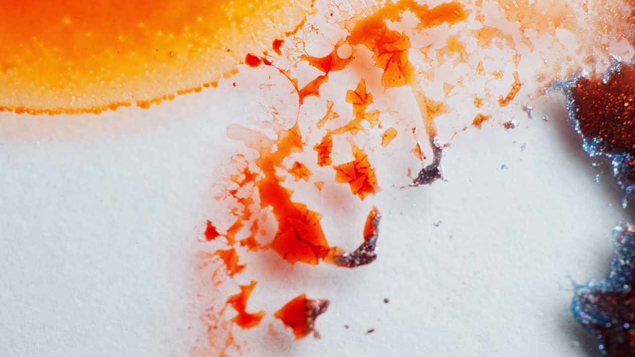 Warm-colored ink in motion creating abstract forms, macro view