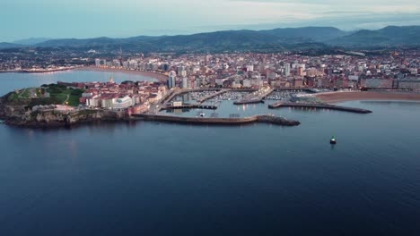 imágenes aéreas del puerto de la playa del océano del paisaje urbano de gijón y el horizonte urbano iluminado al atardecer después del atardecer