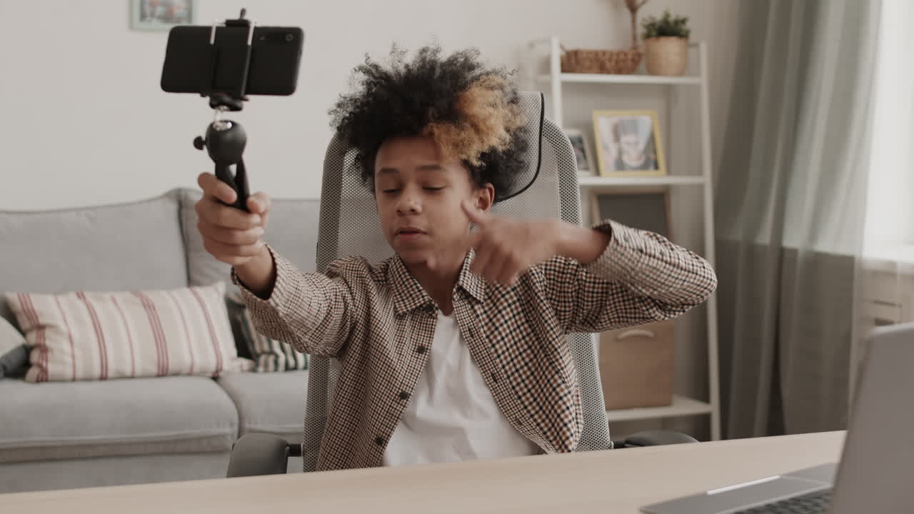 Ragazzo allegro che si riprende con lo smartphone