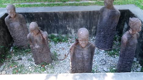 Tilt-up-shot-of-the-stone-monument-of-African-chained-people-near-the-Old-Slave-Market-in-Zanzibar