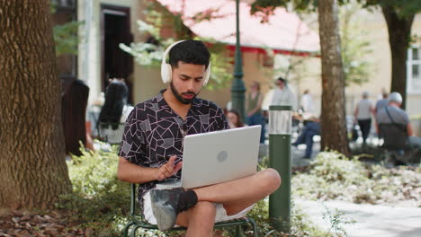 indian man using laptop having video call chat conversation for online meeting presentation outdoors
