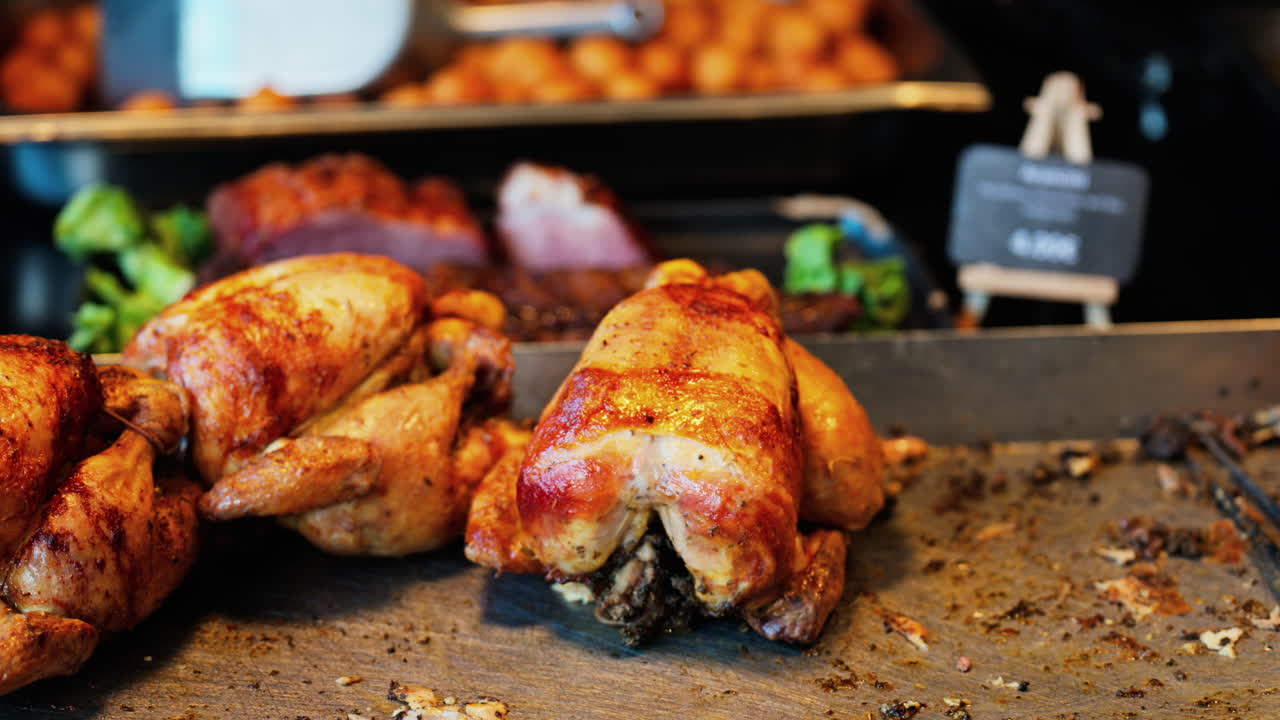 Close up of multiple grilled chickens at a food stand