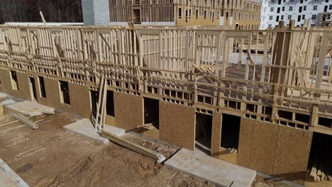 Aerial View of a Large Wooden Building Being Constructed at a Site. This video shows an aerial view of a large wooden building under construction, highlighting the assembly of wooden frames and the scale of activities
