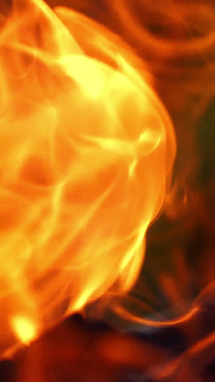Bonfire burning at night. Flames of fire on black background. Fire flame Vertical video