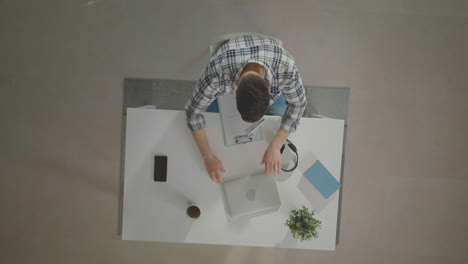 man finishing work at desk