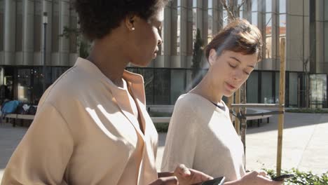 beautiful young women talking while walking on street