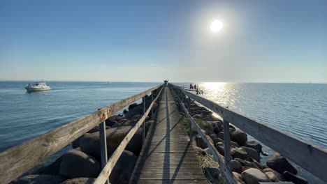 walking on a board walk near sail boat