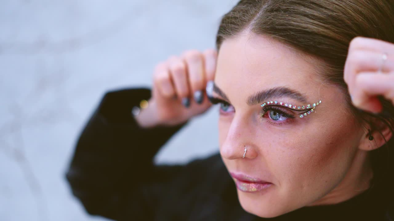 Young Woman with Elaborate Rhinestone Eye Makeup and Decorated Nails