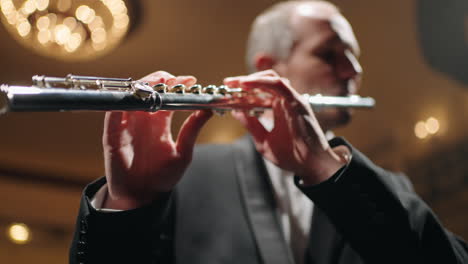 flautista talentoso está tocando la flauta retrato de músico en concierto en la vieja ópera o sala filarmónica