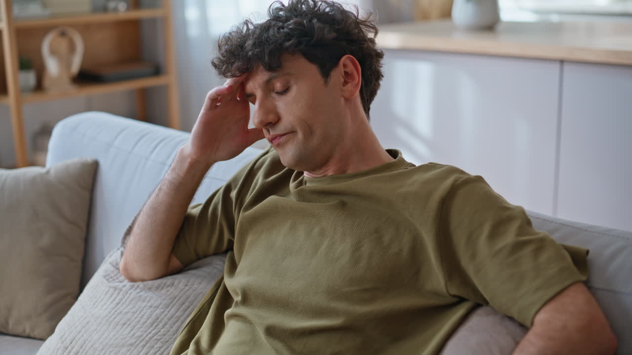 Closeup tired freelancer falling on couch taking work break at home. Guy resting