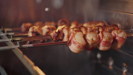 espigas de cerdo envueltas en tocino cocinando en una rosera