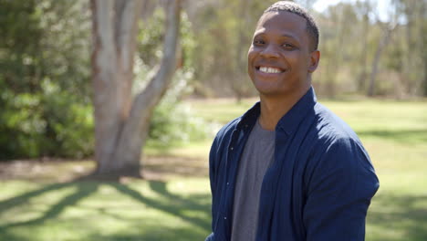 Happy-mixed-race-man-in-countryside-walks-in-to-focal-plane