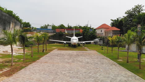 drone flying straight towards and over the famous, abandoned airplane in bali