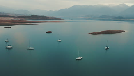 Ein-Ruhiger-See-Inmitten-Von-Berggipfeln,-In-Dem-Boote-Elegant-Durch-Ruhige-Gewässer-Navigieren-Und-Einen-Friedlichen-Rückzugsort-In-Der-Umarmung-Der-Natur-Bieten