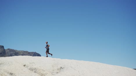 senior african american man exercising running on rocks by the sea