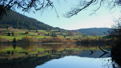 mountain lake in autumn day with branches in foreground