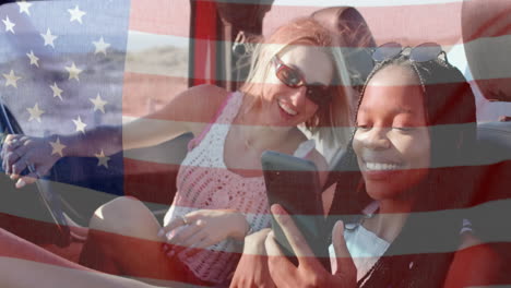 Animation-of-flag-of-usa-over-happy-diverse-women-in-car-by-beach-in-summer