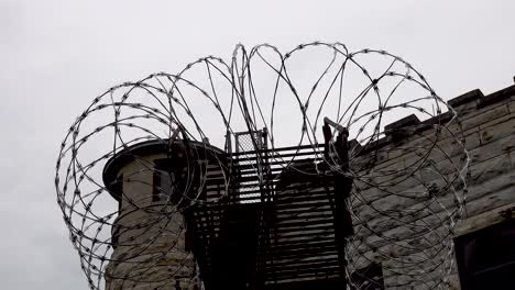 close up barbed wire prison guardhouse timelapse under gray cloudy sky 4k