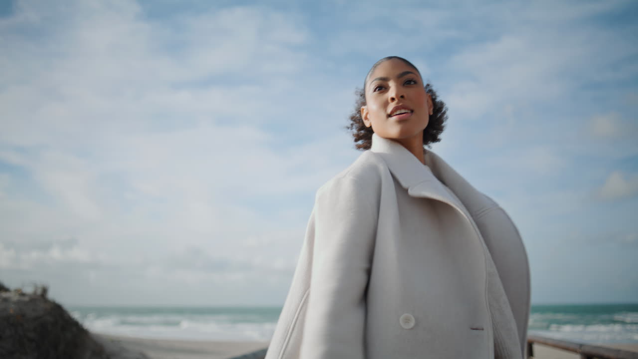 ragazza dai capelli neri che gira sulla spiaggia che celebra la vita. modella allegra che si gode il viaggio