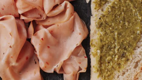 ham italian mordatella, man slices of traditional italian antipasti mortadella sausage on a wooden cutting board, close up macro of chicken or turkey jamon, fat breakfast dish.